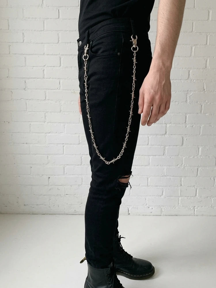 Barbed wire pants chain worn on black ripped jeans