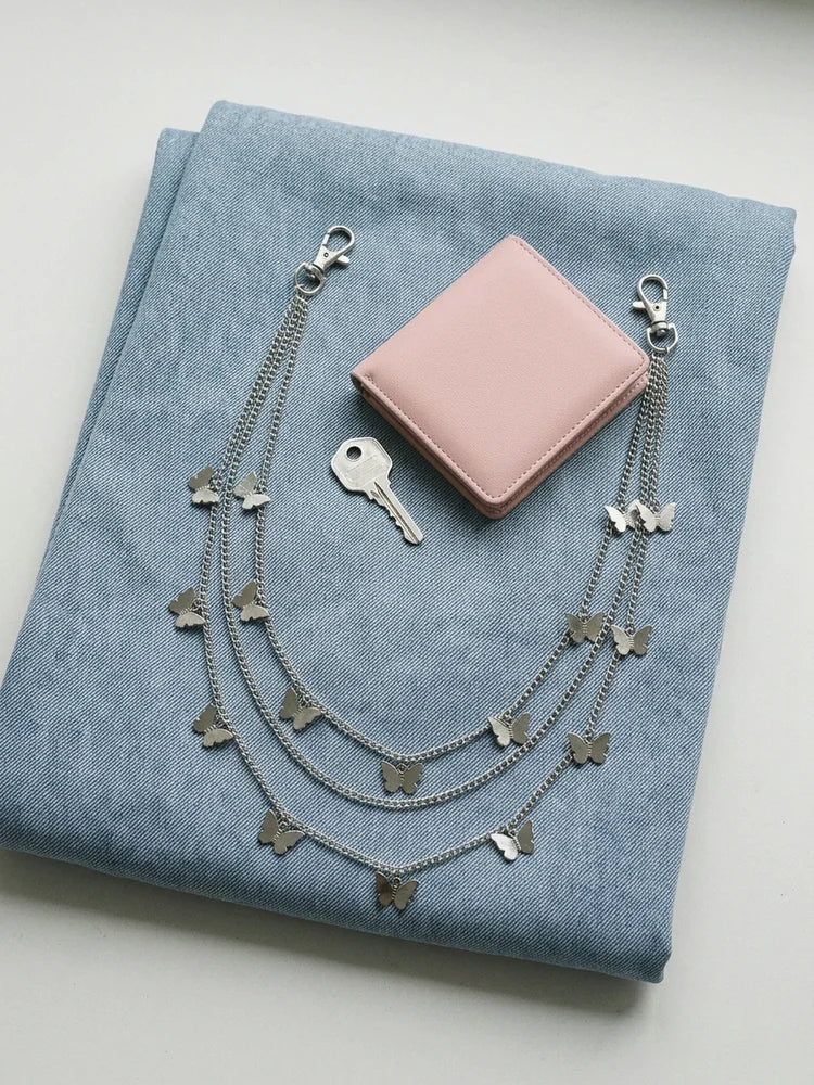 Butterfly pants chain flat lay with pink wallet