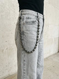 Skull pants chain worn on light grey jeans
